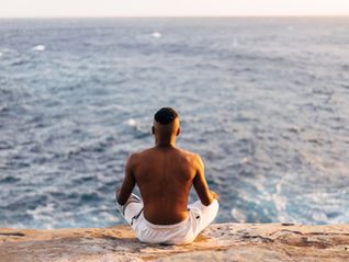 Man sitting by ocean