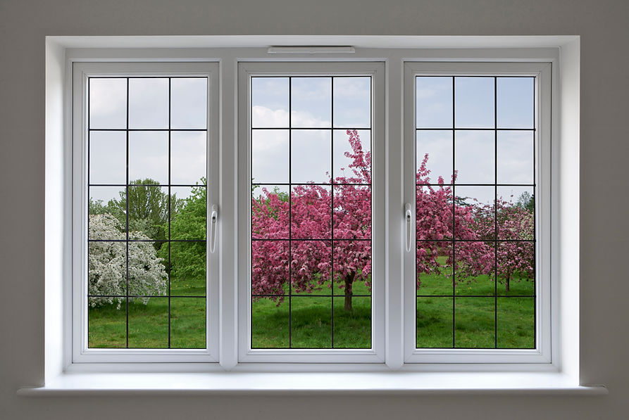 View through a white-framed window showing a serene garden with vibrant pink