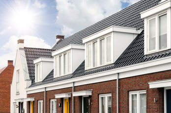 Row of brick houses with white dormer windows