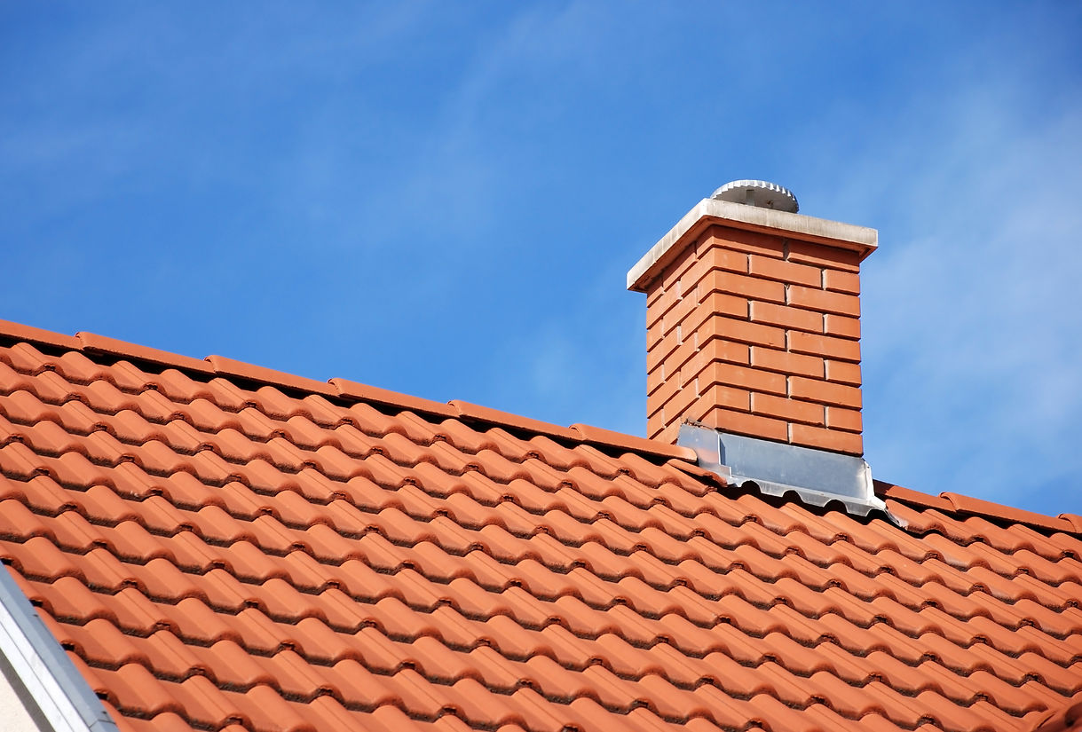 smoke stack on the tiled roof of a family house