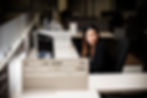 A low key shot of a woman in an office at night accessing a computer