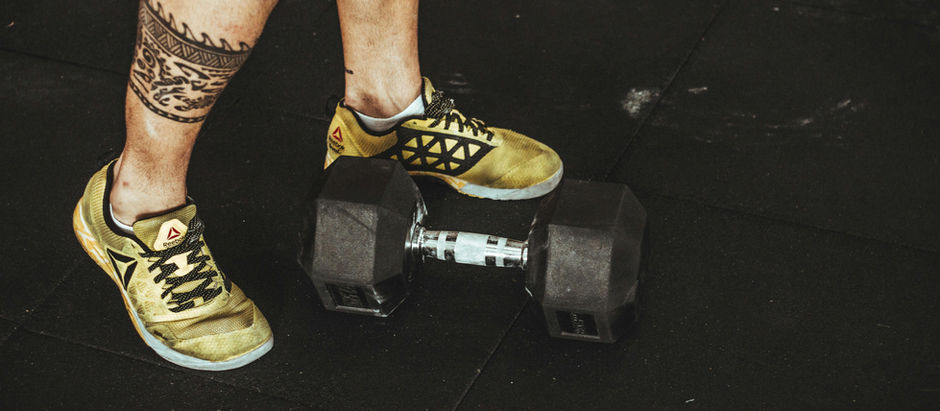 Bărbat lângă ganteră, simbol al sănătății masculine și fitnessului