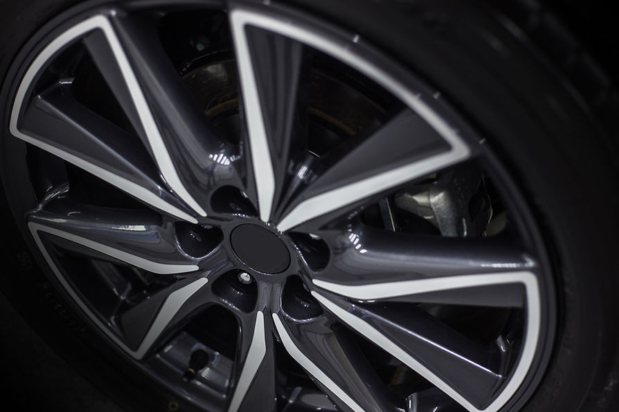 Close-up of a sleek, modern car wheel with a glossy black and silver alloy rim