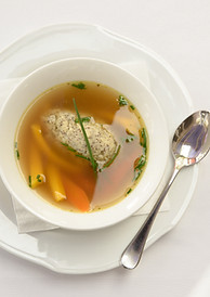 Plate of broth with dumplings and vegetables