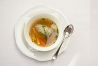 Plate of broth with dumplings and vegetables