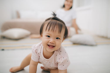 Asian baby crawling while smiling