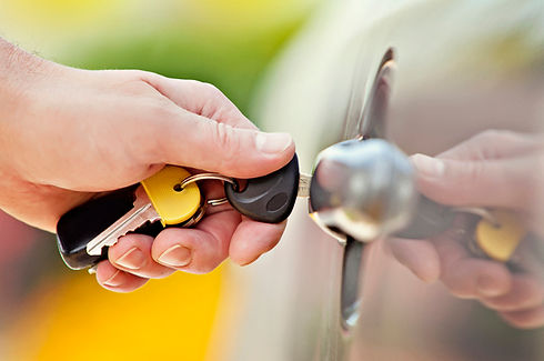 A close-up of a hand putting car keys in a keyhole
