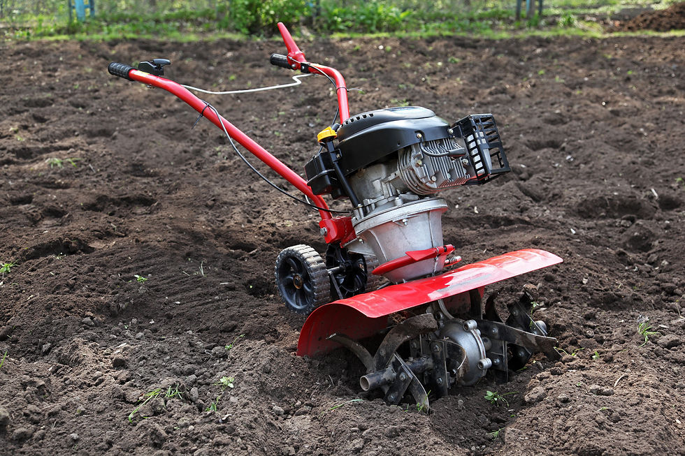 Red walk behind rotavator tilling soil on farmland