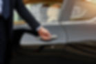 Close-up view of the hands of a male chauffeur opening a car door
