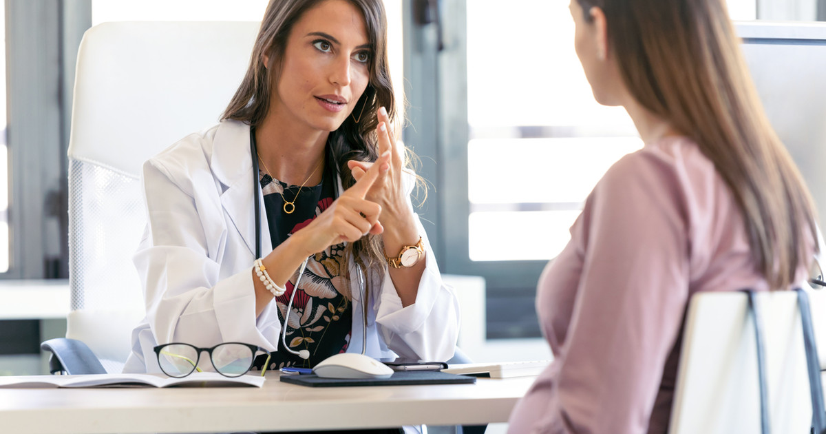 A pain specialist discussing treatment options with a patient using a model of the spine to explain how procedure-based interventions fit within a comprehensive pain management plan.