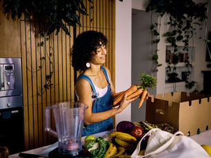 A woman in kitchen with box of vegetables