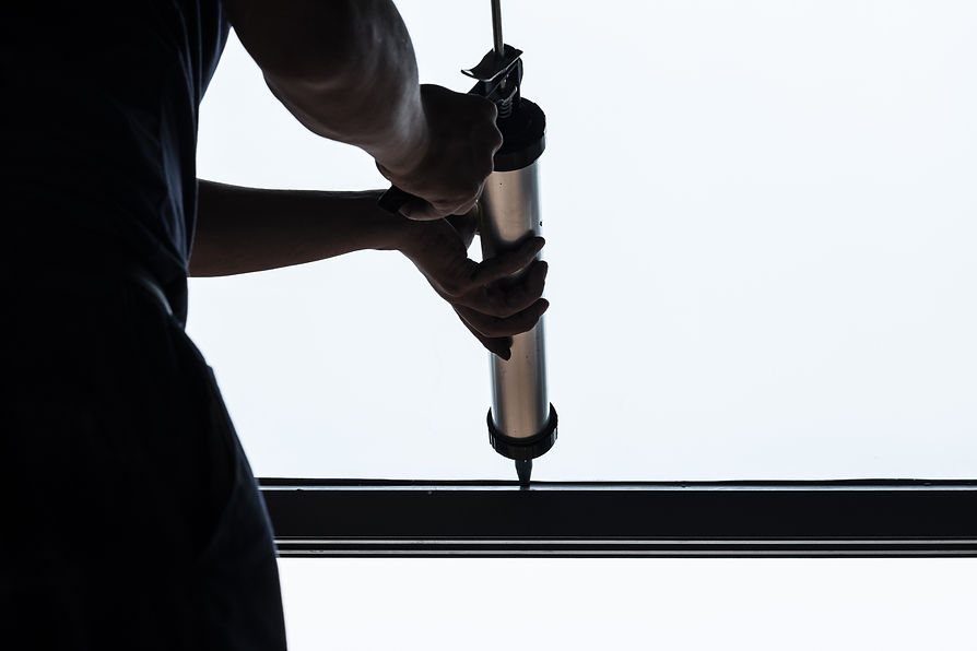 operative precision sealing dark metal frame with a caulking gun