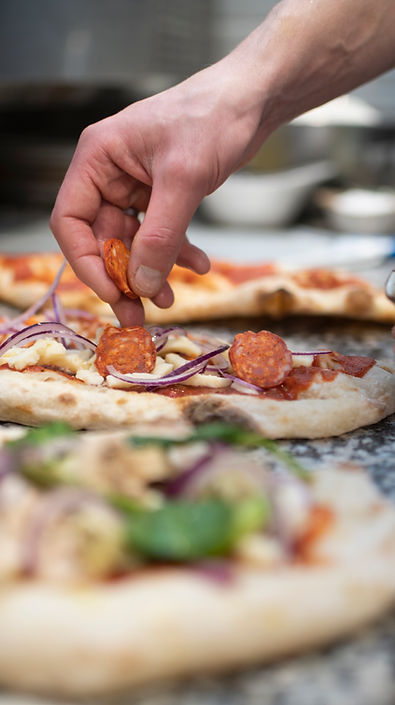 Koch bereitet Pizza zu