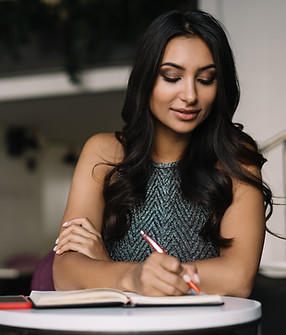 A Woman Sitting in a Coffee Shop and Writing