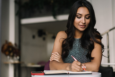 A Woman Sitting in a Coffee Shop and Writing