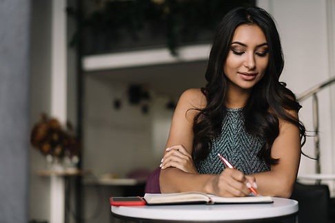 A Woman Sitting in a Coffee Shop and Writing