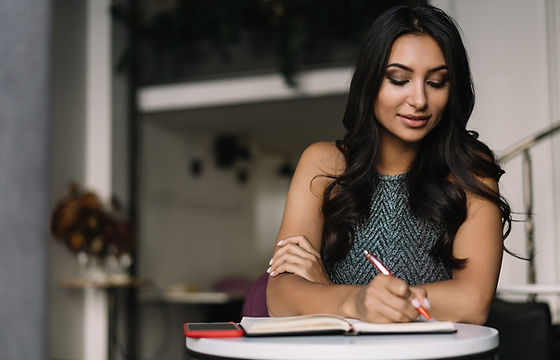 A Woman Sitting in a Coffee Shop and Wri