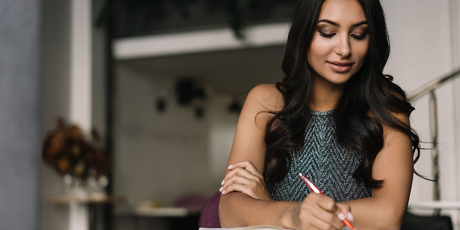A Woman Sitting in a Coffee Shop and Wri