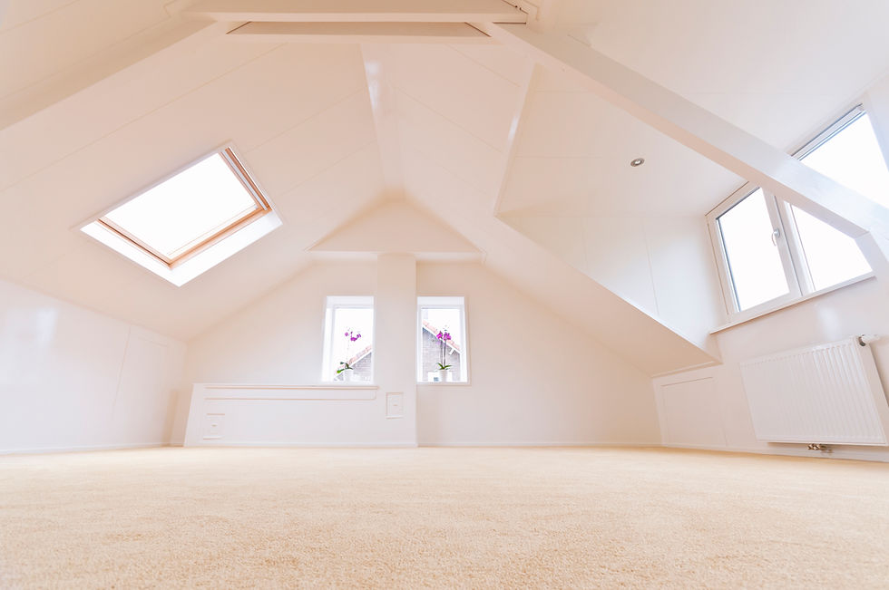 Empty minimalist attic room with sloped ceilings, carpet, and several windows