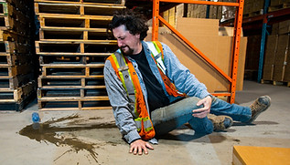 An industrial, warehouse, workplace safety topic. An employee risks injury by slipping