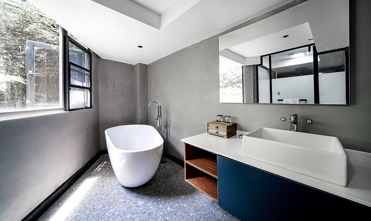 Sleek bathroom vanity setup with double basins, modern faucets, and a large wall mirror reflecting a window