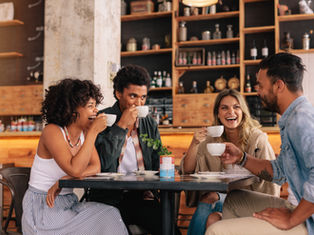 Amigos conversando en un ambiente tranquilo mientras toman café, mostrando apoyo emocional y cercanía, simbolizando la fuerza de la amistad en tiempos difíciles y su papel en la recuperación personal.