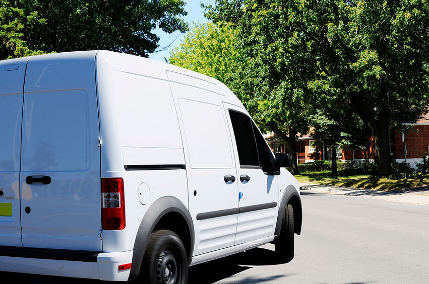 White delivery van parked on residential street in daylight