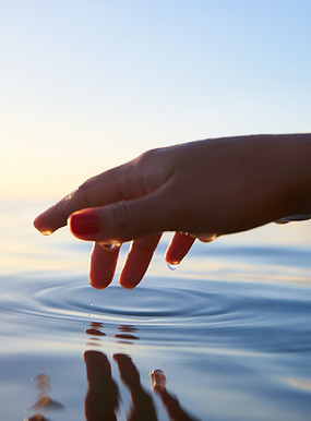 Hand, die Wasser berührt