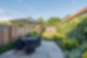 A general view of a back garden on a sunny hot day with clear blue sky of a home