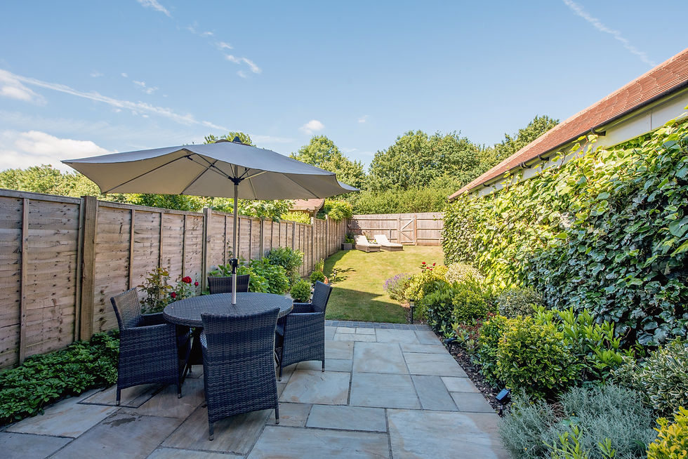 A general view of a back garden on a sunny hot day with clear blue sky of a home
