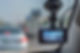 A car dashboard camera records traffic on a busy road, showcasing a clear, sunny day
