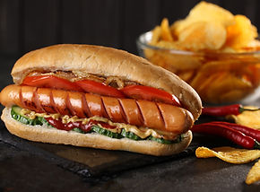 Gegrillter Hotdog mit Tomaten, Gurken und Chips im Flippy-Land Hüpfburgenpark