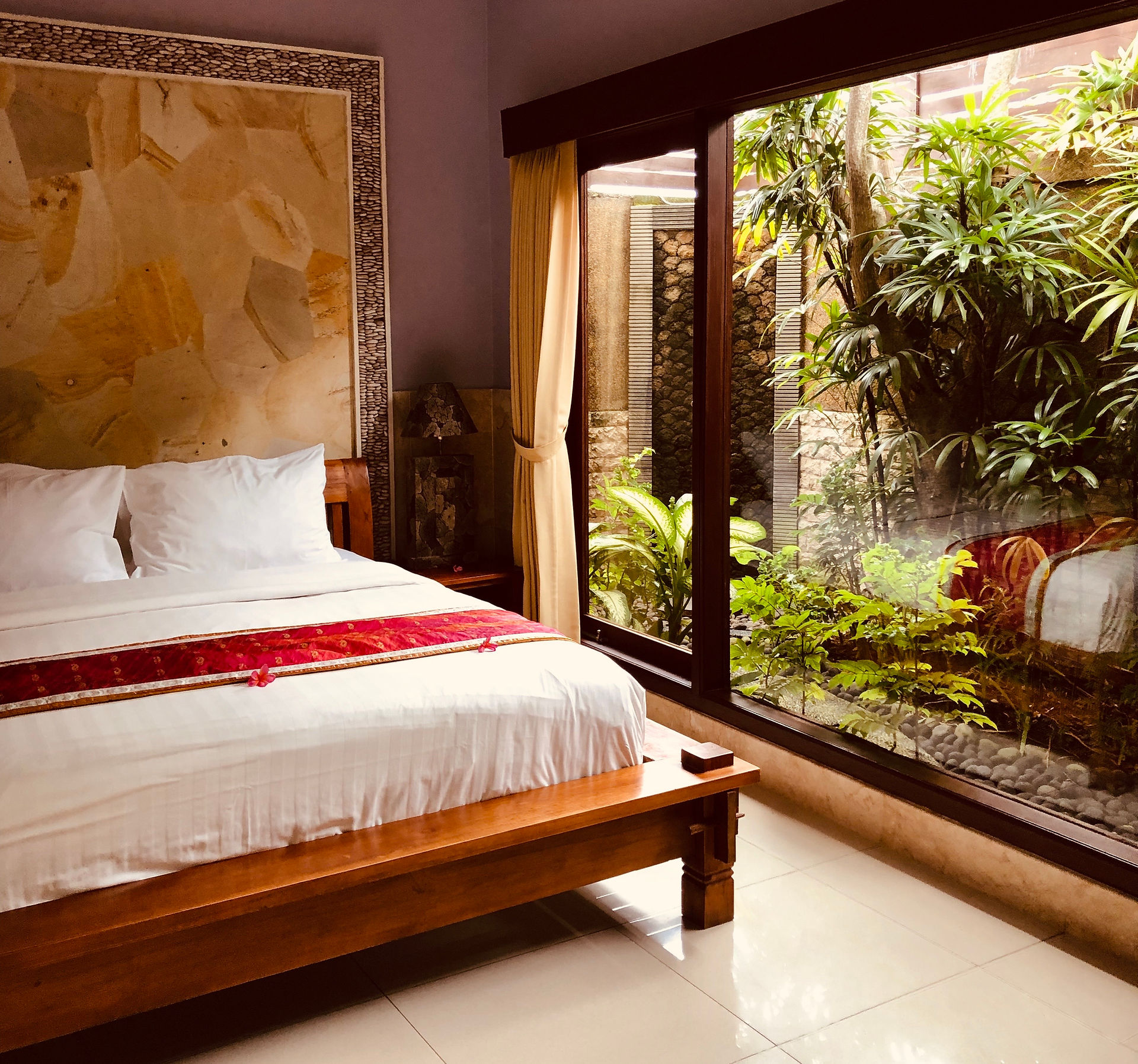 A spacious, comfortable room with a king-size bed and a window offering a view of the garden, creating a peaceful atmosphere.