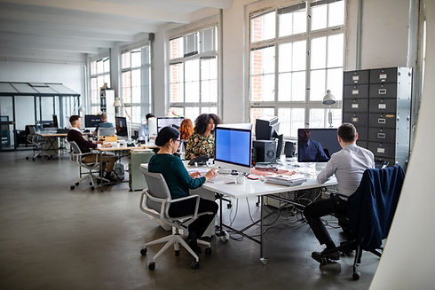 People working in a busy open plan office. Busy office with workers at desks working on co