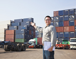 Smiling Person Standing In Front Of Container Yard