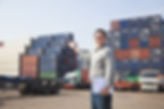 Smiling Person Standing In Front Of Container Yard