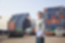 Smiling Person Standing In Front Of Container Yard