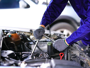 Mechanic with tools working under a car hood — voice task assignment for auto shop mechanics