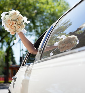 Bride Waving Flowers in Limo