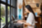 A woman using a laptop PC in a cafe