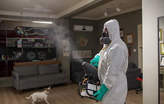 man in protective suit disinfecting and spraying every room in the building