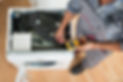 High angle view of technician checking washing machine with digital multimeter in kitchen