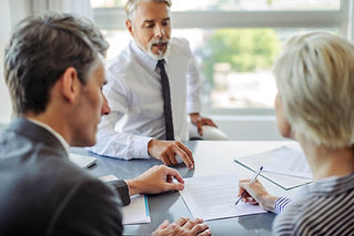 Three professionals in an office, engaged in discussion.