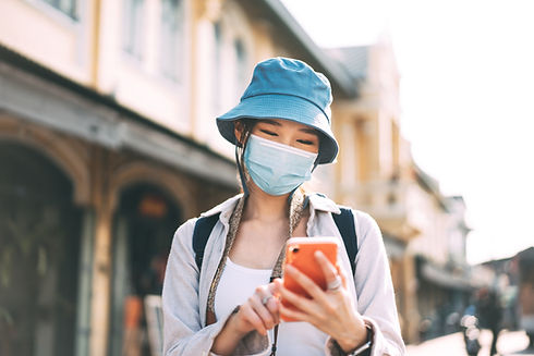 Person in Mask Looking At Smartphone