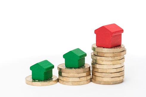 Stack of new British one-pound coins with red and green toy houses