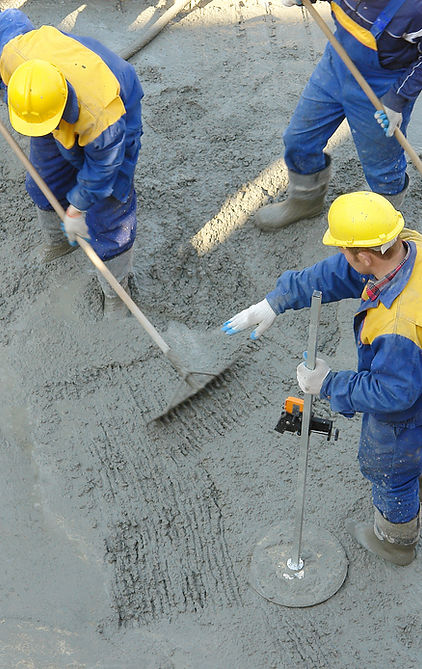 Construction workers spreading freshly poured concrete