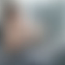 ผู้หญิงในชุดออกกำลังกายสีเทา กำลังพักผ่อนด้วยการฟังเพลงจากโทรศัพท์มือถือ หลังออกกำลังกายแบบ weight training