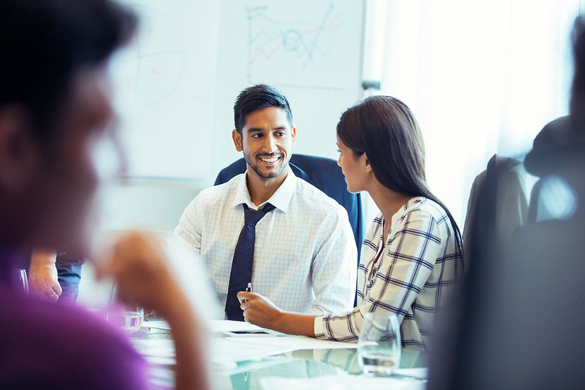 Businesswoman and businessman sitting and talking in conference room during business meeting