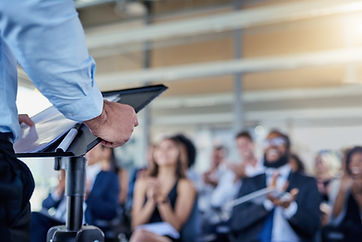 Person delivering a presentation to a clapping audience
