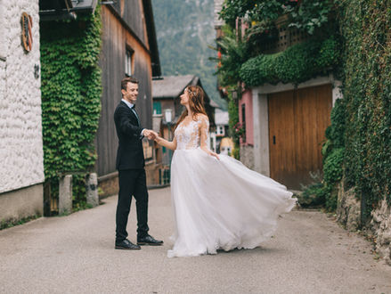 Ein lachendes Hochzeitspaar das sich an den Händen hält